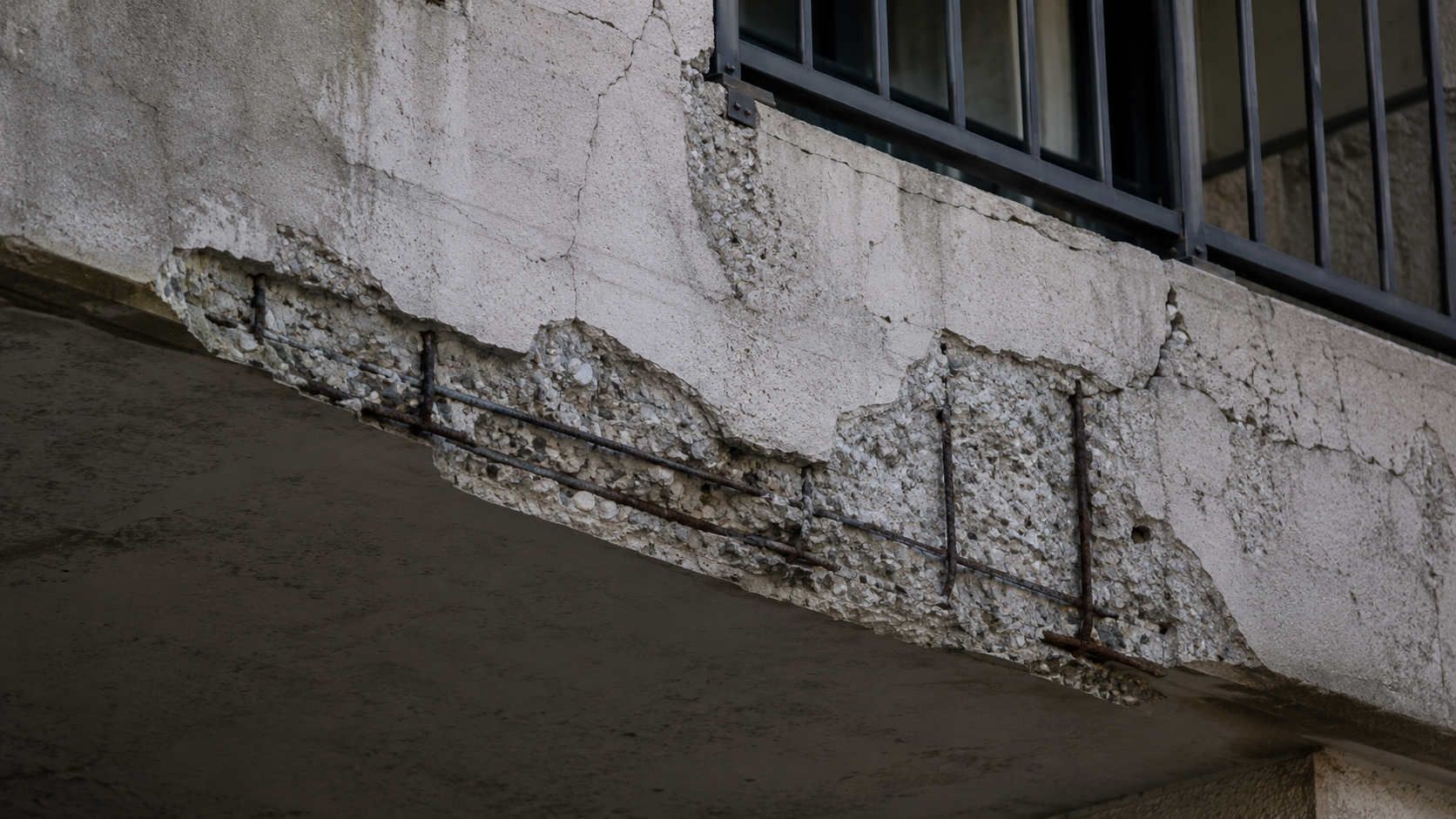 Spalled concrete balcony edge with exposed reinforcing steel